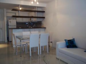 uma sala de estar com uma mesa e cadeiras e um sofá em Green Park Punta del Este em Punta del Este