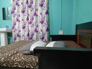 a bed with two pillows and a shower curtain at Comfort Inn Kamakhya Jn in Guwahati