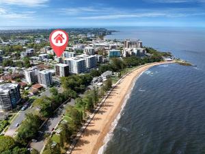 an aerial view of a beach with a street sign at Suttons Cove in Redcliffe