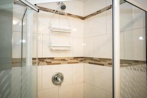 baño con ducha y puerta de cristal en Cozy private bedroom and living room in our home en Gatineau