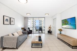 a living room with a couch and a table at Suttons Cove in Redcliffe
