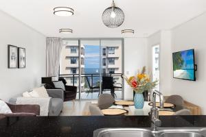 a kitchen and living room with a view of the ocean at Suttons Cove in Redcliffe
