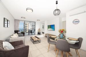 a living room with a couch and a table at Suttons Cove in Redcliffe