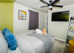 een slaapkamer met een wit bed en een plafondventilator bij Friends Haven: Truist Park 8mins in Smyrna
