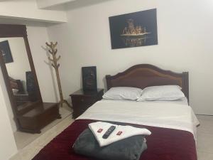 a bedroom with a bed with two remotes on it at Hospedaje Casa Dorada - Modelia in Bogotá