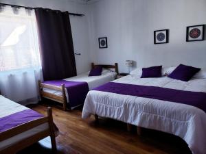 Kama o mga kama sa kuwarto sa Hostal Arrayan