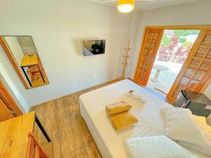 - une chambre avec un lit blanc et une grande fenêtre dans l'établissement Pousada Ar da Montanha, à Serra Negra