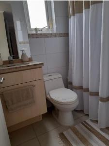 La salle de bains est pourvue de toilettes, d'un lavabo et d'une fenêtre. dans l'établissement Viña plaza 6 departament, à Viña del Mar