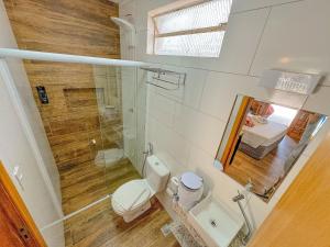 een badkamer met een toilet, een douche en een wastafel bij Pousada Ar da Montanha in Serra Negra