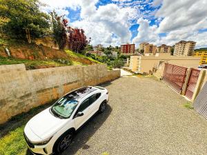 a white car parked on the side of a road at Pousada Ar da Montanha in Serra Negra