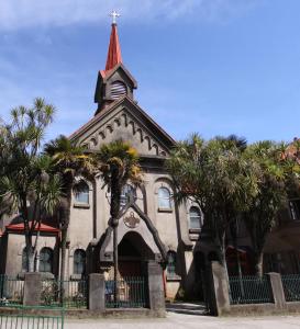 a church with palm trees in front of it at Hostal Arrayan in Valdivia