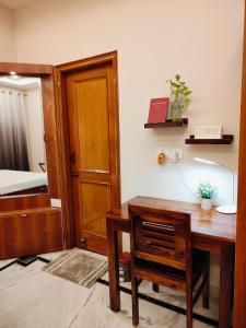 Zimmer mit einem Schreibtisch und einem Schlafzimmer mit einem Bett. in der Unterkunft Aura Home Stay in Mohali