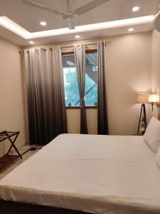 ein Schlafzimmer mit einem großen Bett und einem Fenster in der Unterkunft Aura Home Stay in Mohali