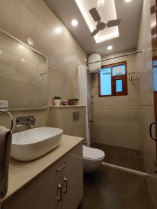 ein Badezimmer mit einem Waschbecken, einem WC und einem Spiegel in der Unterkunft Aura Home Stay in Mohali