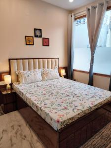 Bett in einem Schlafzimmer mit Fenster in der Unterkunft Aura Home Stay in Mohali