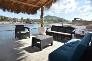 d'une terrasse avec un canapé et des chaises offrant une vue sur l'eau. dans l'établissement Sealion Dive Center, à Topolobampo