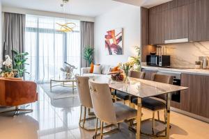 - une cuisine et une salle à manger avec une table et des chaises dans l'établissement Veluxa - Luxe Beach Vista 2 Bed, à Dubaï