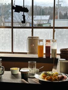a table with a plate of food and glasses of juice at 白馬の黒馬　DarkHorse @Hakuba in Hakuba