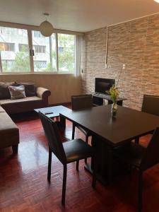 una sala de estar con una mesa y un sofá en Habitación amplia e indep c/ jacuzzi, céntrica., en Ciudad de México
