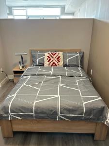 a bedroom with a bed with a gray comforter at 1-bedroom condo near University of Waterloo in Waterloo