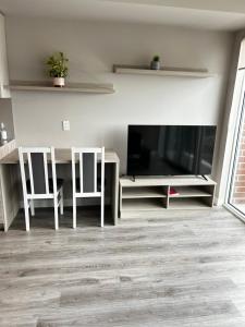 a living room with a table and chairs and a television at 1-bedroom condo near University of Waterloo in Waterloo