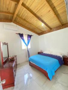 - une chambre avec un lit bleu et un plafond en bois dans l'établissement Fantástico espacio para alojarse, à Puerto Palenque