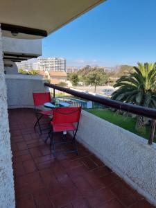 a patio with two chairs and a table on a balcony at Departamento frente al mar 4 personas, La Serena in La Serena