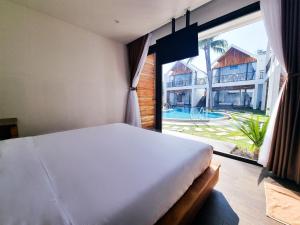 a bedroom with a bed and a large window at Tuong Vy Boutique Hotel Mui Ne in Mui Ne
