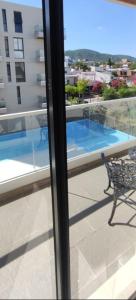 a balcony with a bench and a view of a swimming pool at Accarezza in Villa Carlos Paz +6 photos