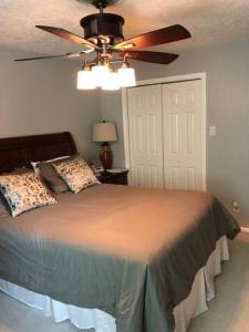 a bedroom with a bed with a ceiling fan at 2 room luxury suite near airport & The Woodlands in Houston