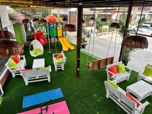 un patio avec des chaises et une aire de jeux avec une balançoire dans l'établissement Katamar, à Manta