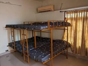 two bunk beds in a room with a window at Modern City Oasis in Kollam