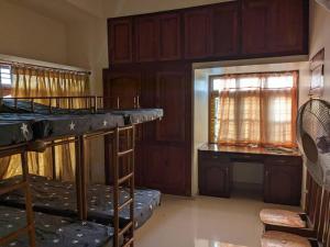 a room with two bunk beds and a desk at Modern City Oasis in Kollam