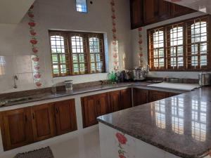 a kitchen with wooden cabinets and a granite counter top at Modern City Oasis in Kollam