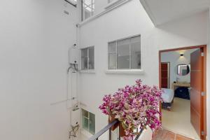 balkon z fioletowymi kwiatami na białej ścianie w obiekcie Blooming Hideaway @ Cadetes 303 w mieście Meksyk