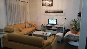 uma sala de estar com dois sofás e uma televisão em Recanto da Família em Guaratuba