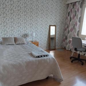 a bedroom with a bed and a desk and a chair at Scandinavian taiteilijan 3h huoneisto in Lahti