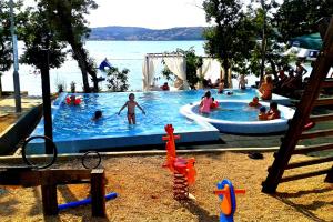 a group of people playing in a swimming pool at Krk Mobile Homes in Klimno