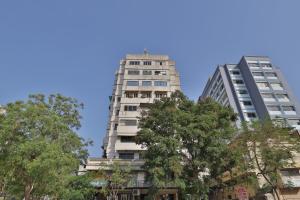 ガンディーナガルにあるHOTEL REST INNの木々が目の前に建つ高層ビル2棟