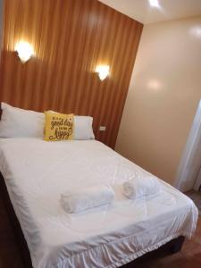 a bed with two towels on it with a yellow pillow at SEAVIEW INN in Catbalogan
