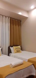a bedroom with two beds with a pillow on it at SEAVIEW INN in Catbalogan