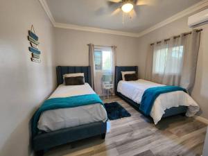 a bedroom with two beds and a ceiling fan at Turquoise Escapes in Black Point