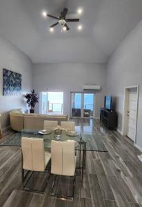 a living room with a glass table and chairs at Turquoise Escapes in Black Point