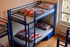 2 łóżka piętrowe w pokoju z poduszkami w obiekcie Saint James Backpackers w Londynie