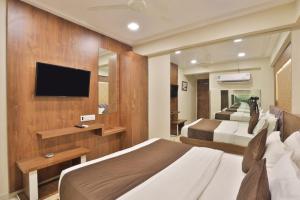 ガンディーナガルにあるHOTEL REST INNのベッドルーム(大型ベッド1台、テレビ付)
