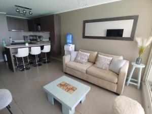 una sala de estar con un sofá y una mesa en Departamento Laguna del Mar, en La Serena