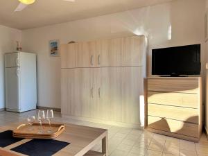 sala de estar con nevera y mesa en Studio Climatisé avec Terrasse et Parking au Centre du Lavandou - FR-1-251-202, en Le Lavandou