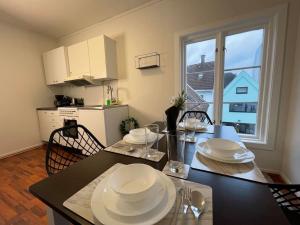 a kitchen with a table with white plates on it at Stavanger BnB 15 by Berti's ( Centrum, Sauna, Billiard, Airport Shuttle) in Stavanger