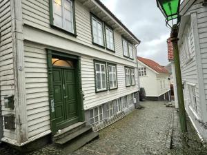 uma porta verde ao lado de uma casa em Stavanger BnB 15 by Berti's ( Centrum, Sauna, Billiard, Airport Shuttle) em Stavanger