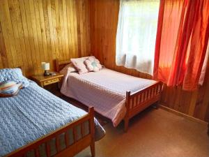 a small bedroom with two beds and a window at Hospedaje Martita. in Putemún